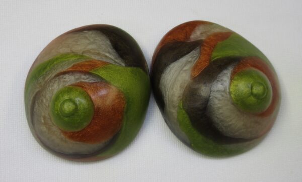 Two green and brown shells are sitting on a table.