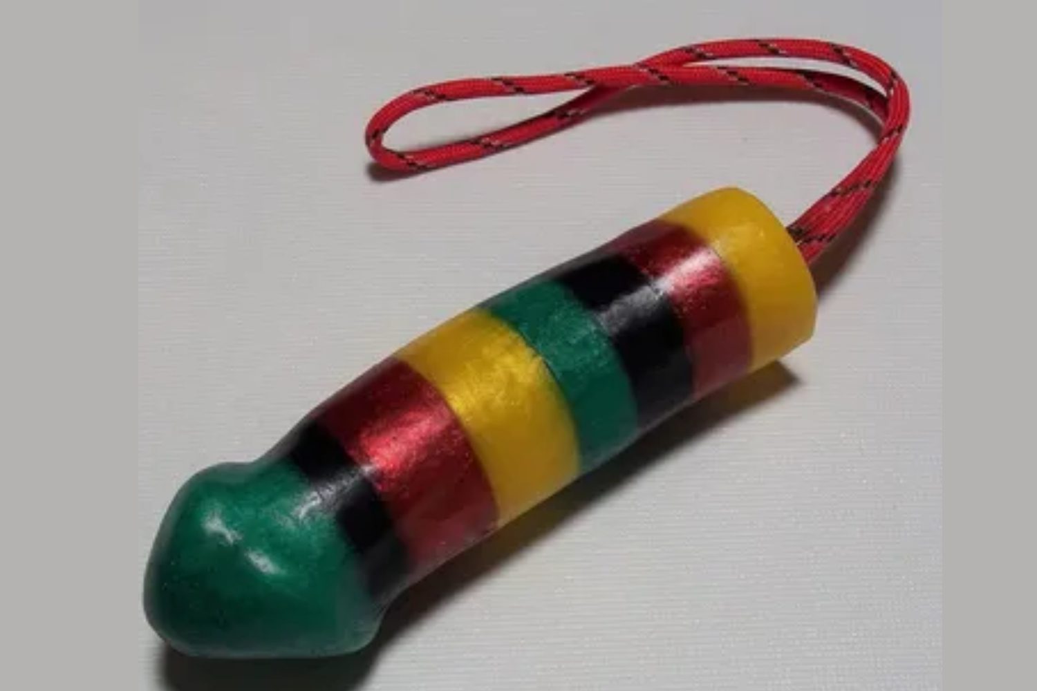 A wooden toy with red, yellow and green stripes.