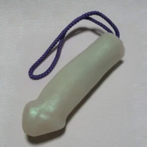 A white plastic toy with purple string on top.