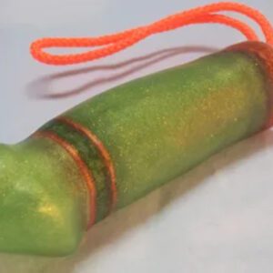 A green toy with orange string hanging from it.