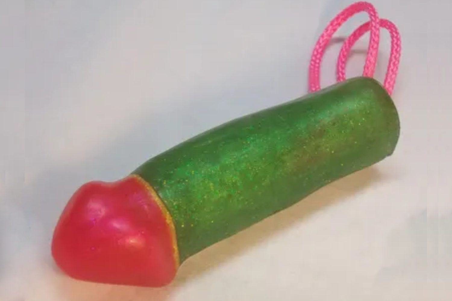 A green and red toy with pink handles.