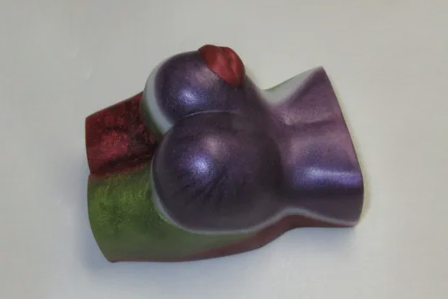 A purple and green soap shaped like a woman 's breasts.