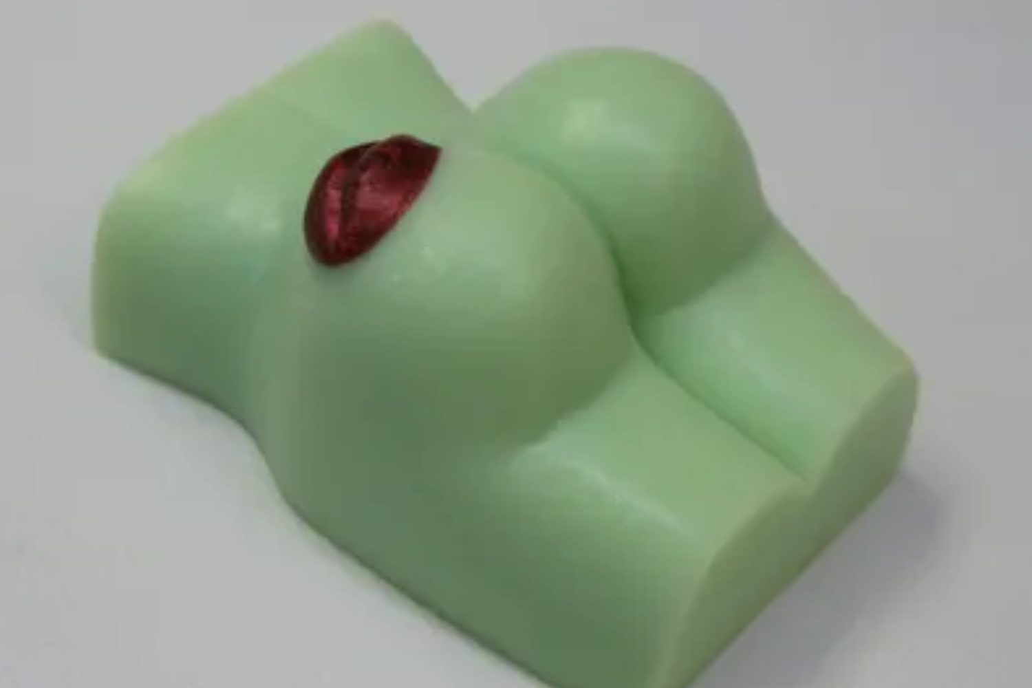 A green soap shaped like a woman 's boobs.