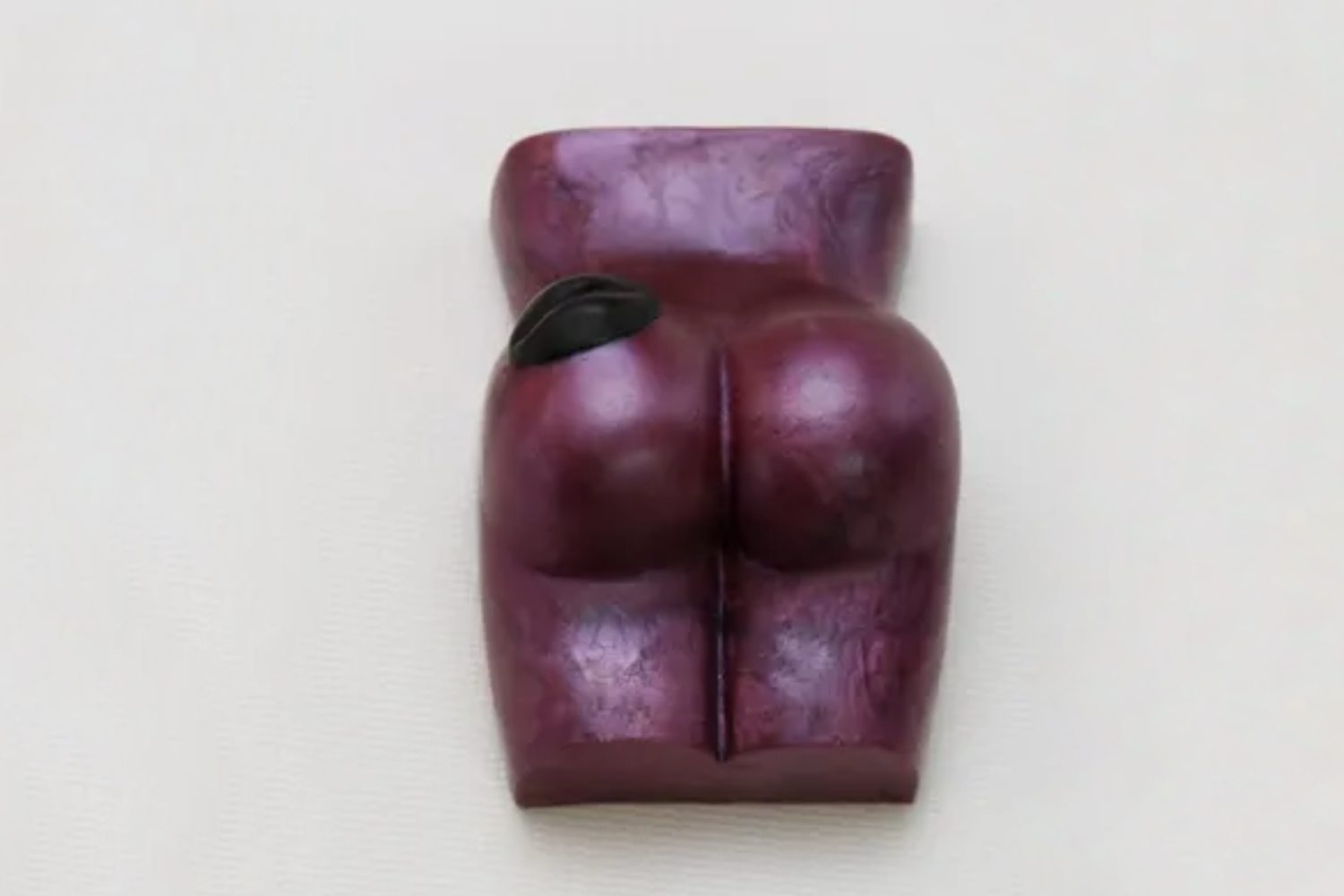 A purple sculpture of a woman 's buttocks.