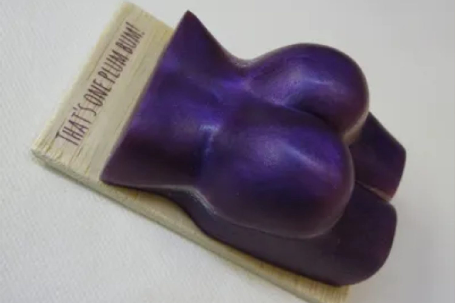 A purple soap shaped like a woman 's breast.