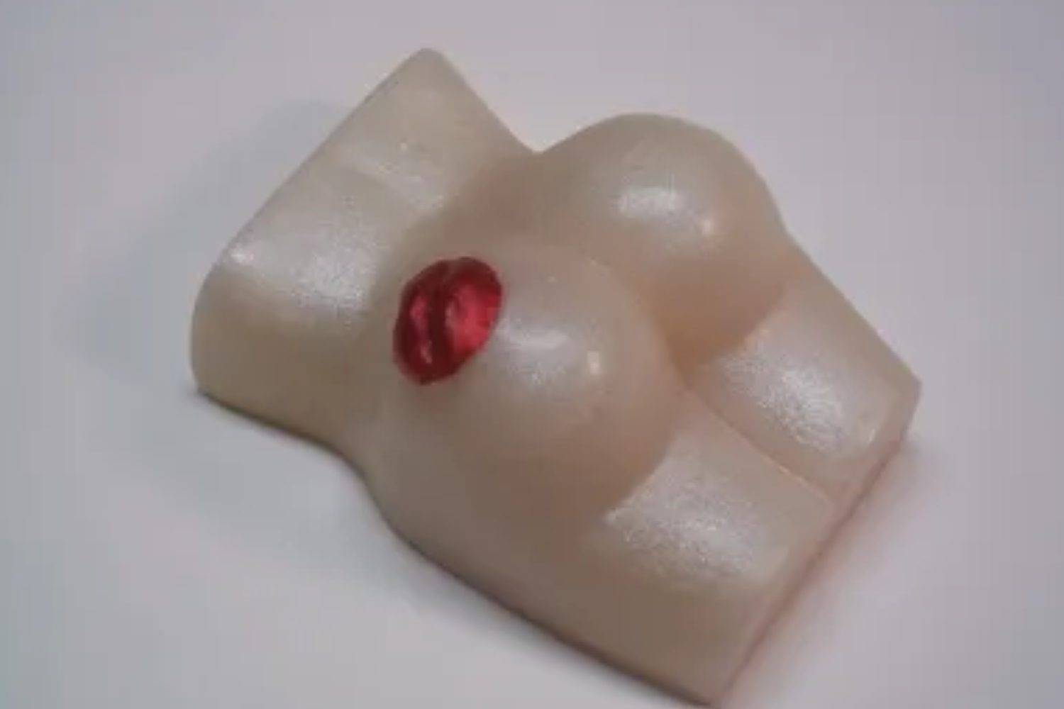 A white soap shaped like a woman 's breast.