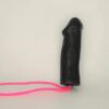 A black rubber glove with pink cord attached to it.