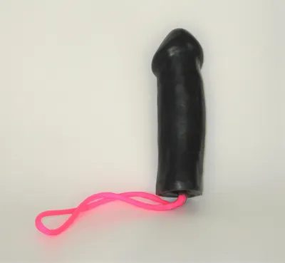 A black toy with pink string on it.