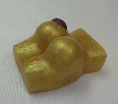 A gold colored soap shaped like a person.
