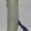 A white plastic tube with purple string attached to it.