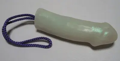 A white plastic tube with purple string on top of it.