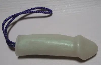 A white plastic tube with purple string attached to it.