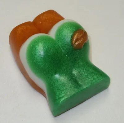 A green and orange piece of candy sitting on top of a table.