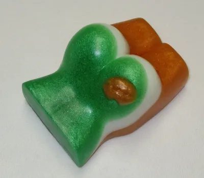 A green and white soap with a brown mitt on top of it.