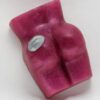 A pink piece of wax with a coin in the middle.