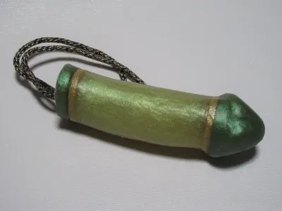 A green and gold pendant on a black cord.