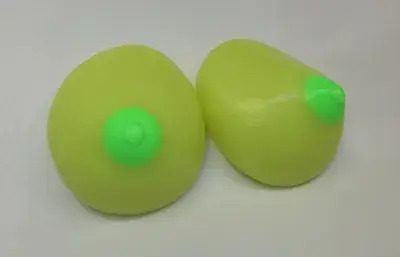 Two green balls are sitting on a table.