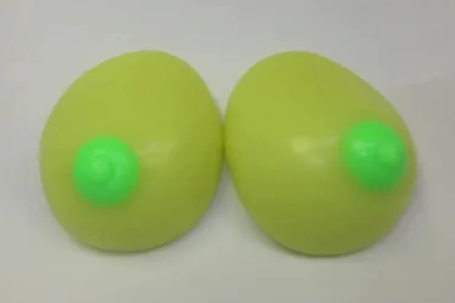 Two green eggs with a green ball on top of them.