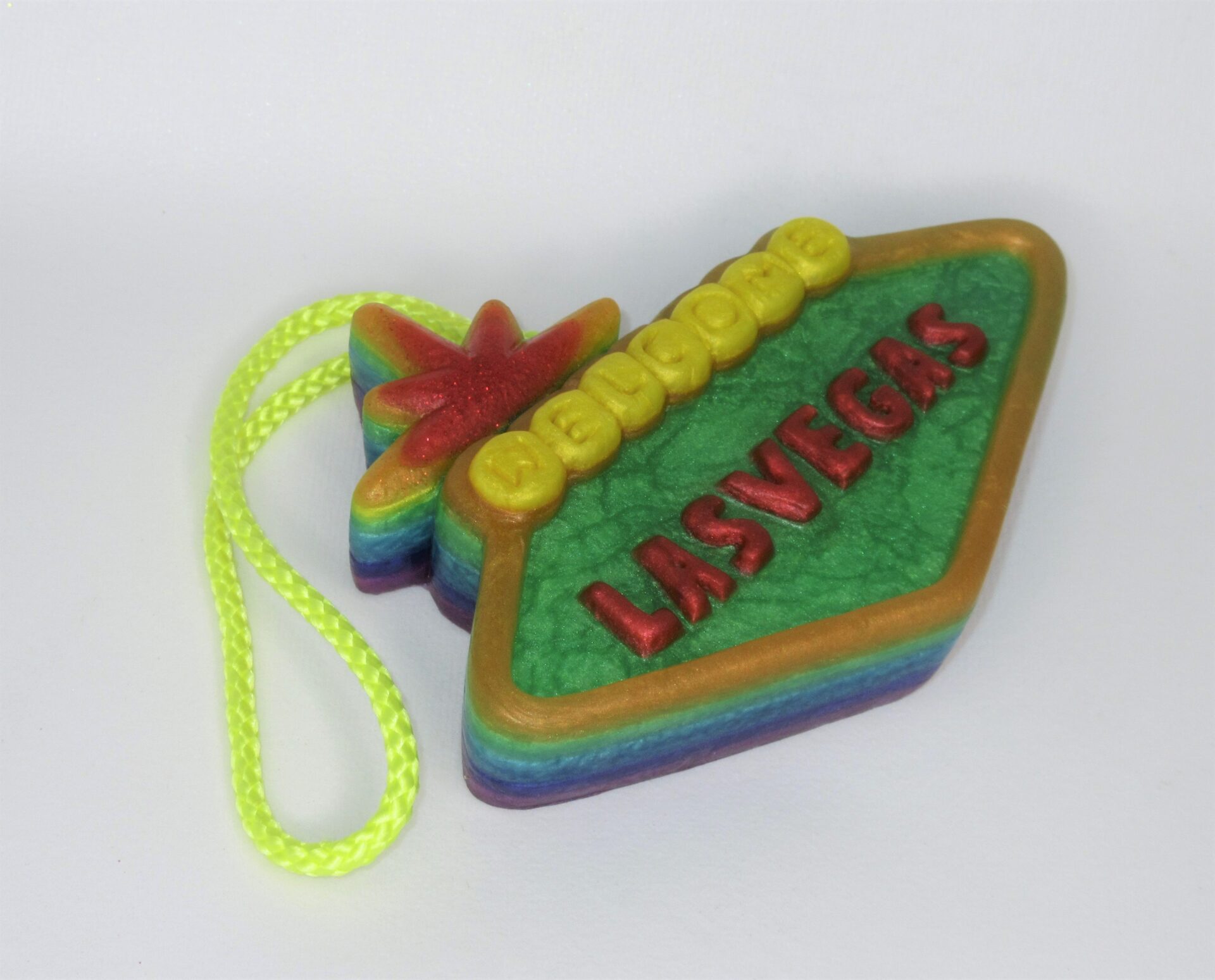 A colorful las vegas sign ornament with a yellow string.