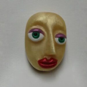 A yellow face with green eyes and red lips.