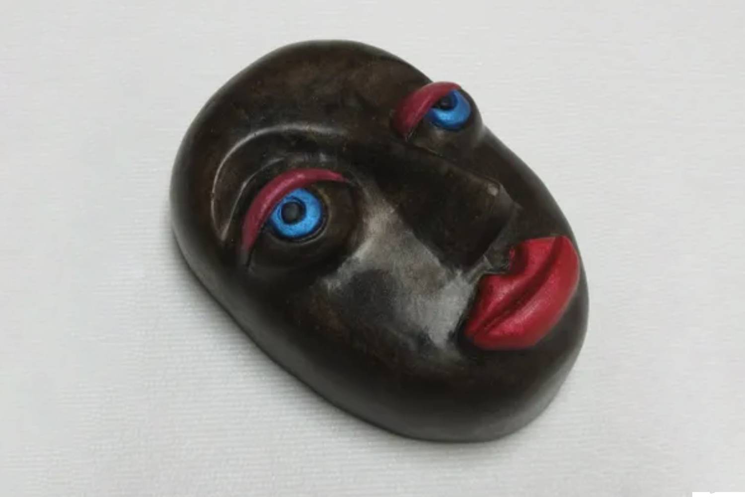 A black face with blue eyes and red lips.