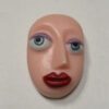 A close up of a face on top of a white wall.