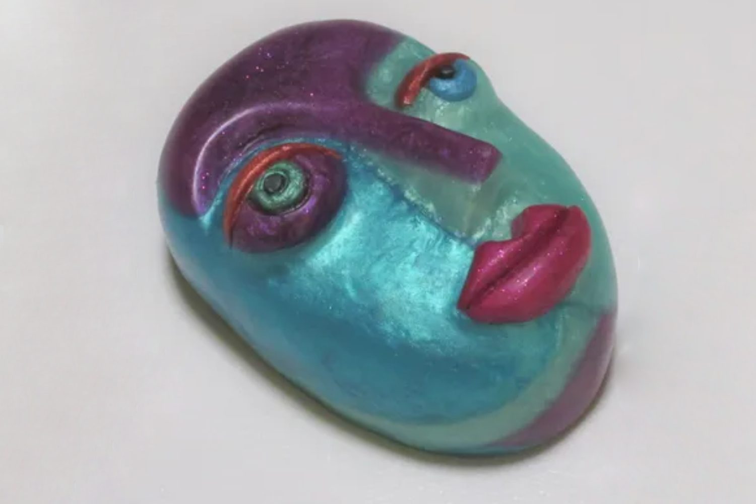 A blue face with purple lips and eyes.