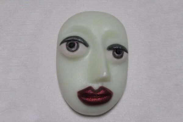 A white face with red lips and black eyes.