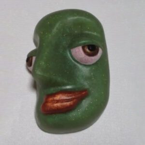 A green face with brown eyes and red lips.