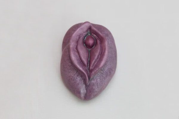 A purple piece of clay with a woman 's breast.
