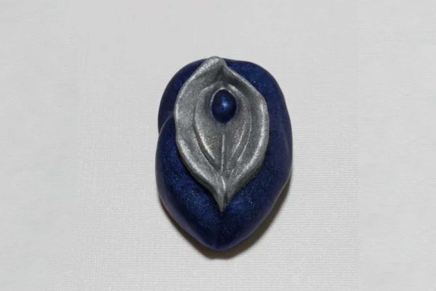 A blue and silver leaf shaped bead.