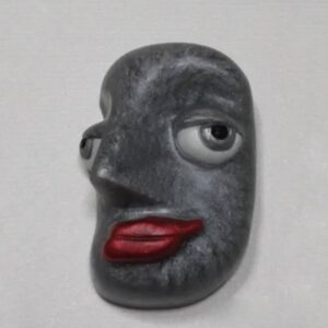 A gray face with red lips on the wall.