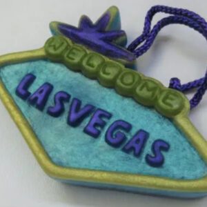 A blue and green welcome sign with the word " las vegas " written on it.