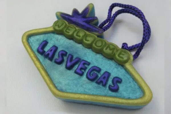 A blue and green welcome sign with the word " las vegas " written on it.