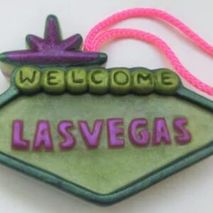 A green and purple sign that says " welcome las vegas ".