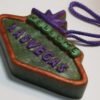 A green and purple sign hanging from a string.