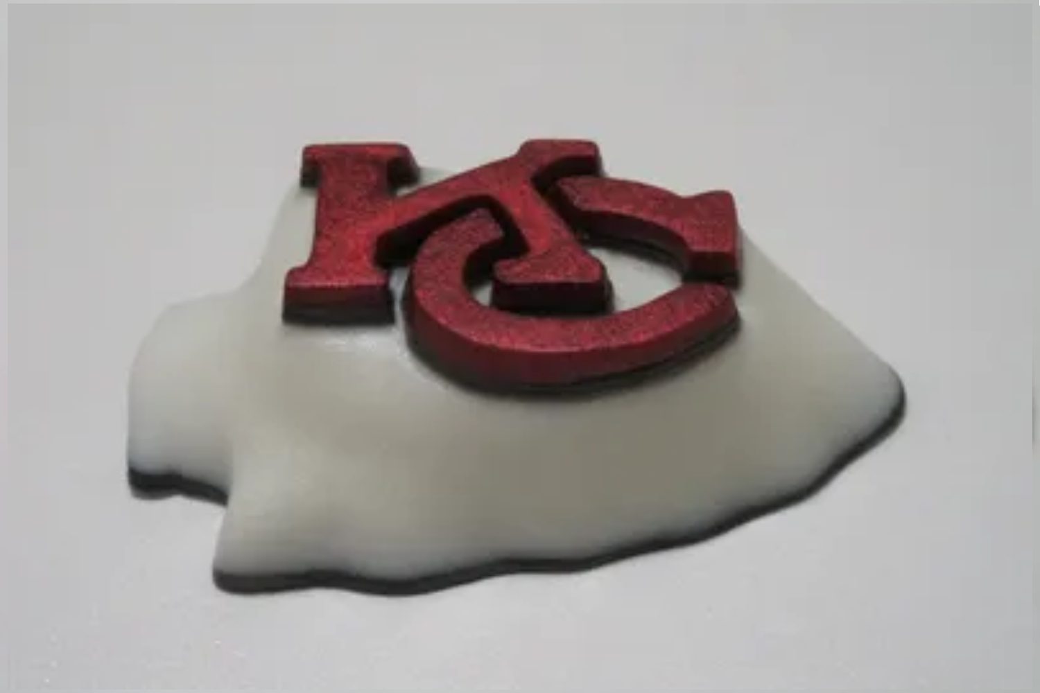 A red and white clay piece of paper with the kansas state logo on it.