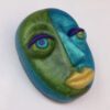 A green and blue face with yellow eyes.