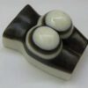 A white and black object with two candles on top.
