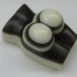 A white and black object with two candles on top.