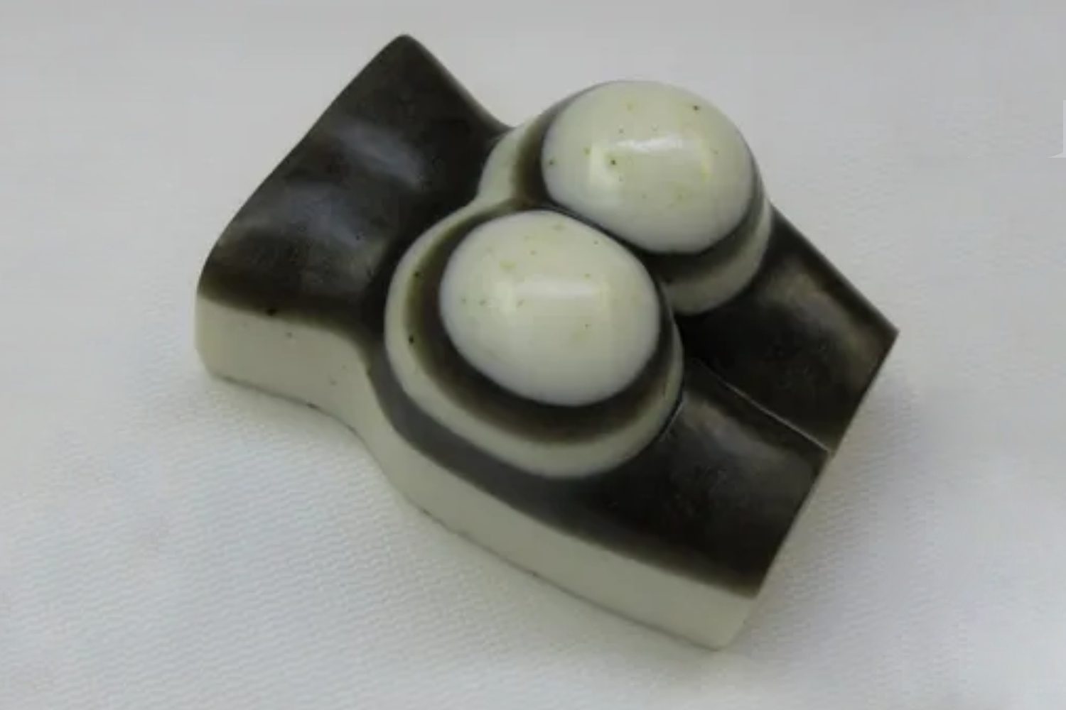 A white and black object with two candles on top.
