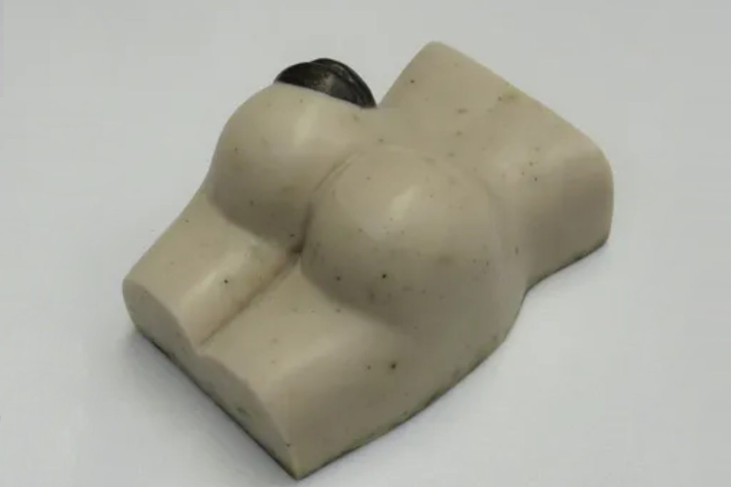 A white piece of soap shaped like a woman 's buttocks.