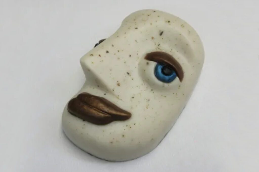 A white face with brown lips and blue eyes.