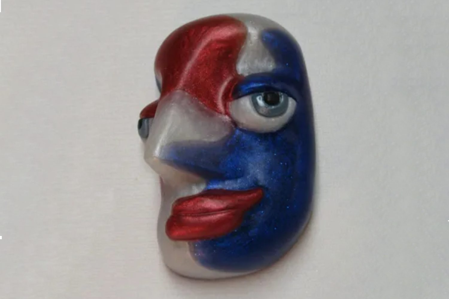 A blue, white and red face with a big eye.
