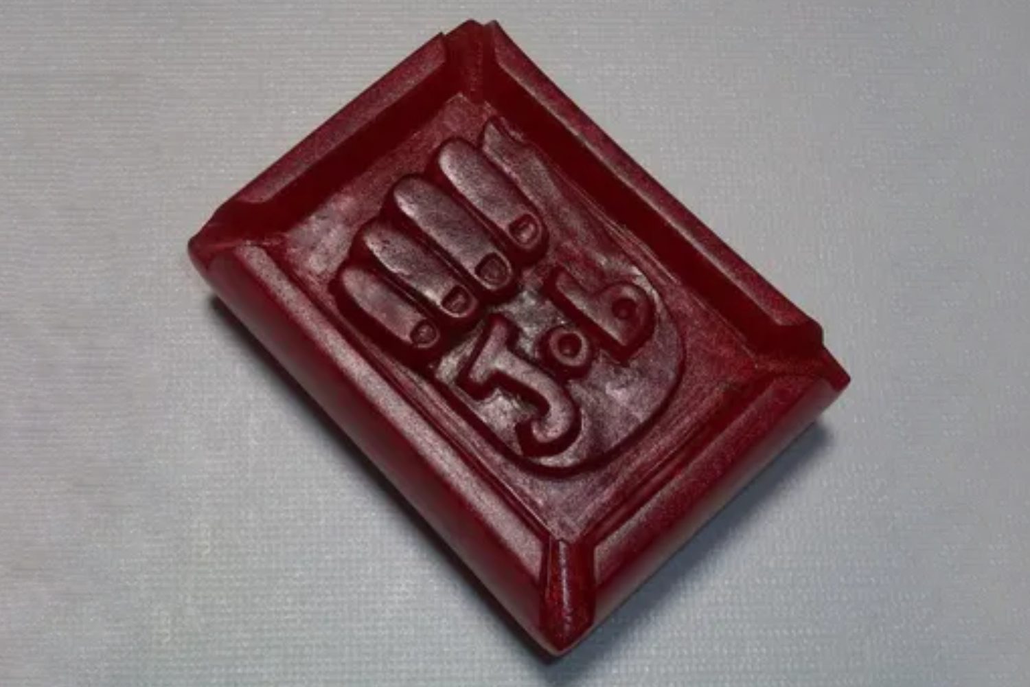 A red rectangular object with the number 5 3 carved into it.