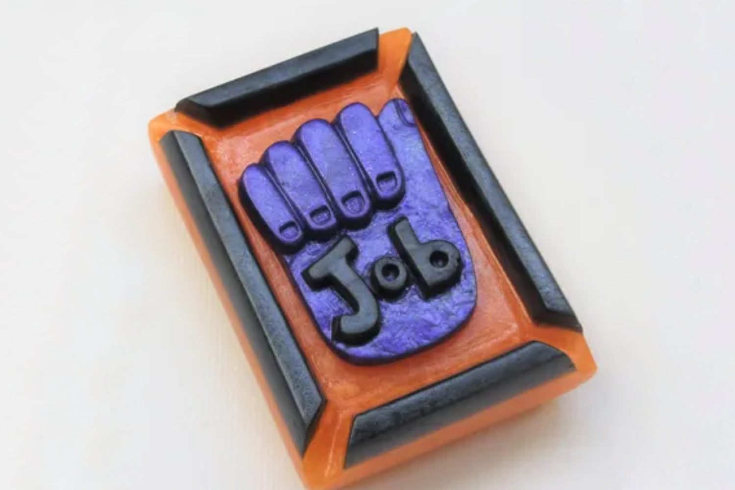 A hand shaped soap with the word job on it.