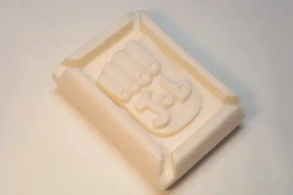 A white soap bar with the word " yes " in it.