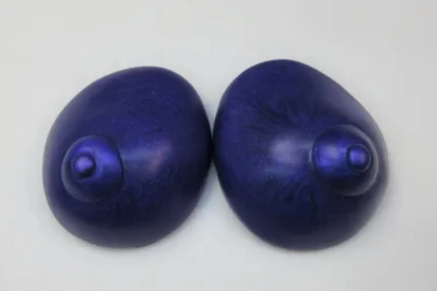 Two blue eggs are sitting on a table.