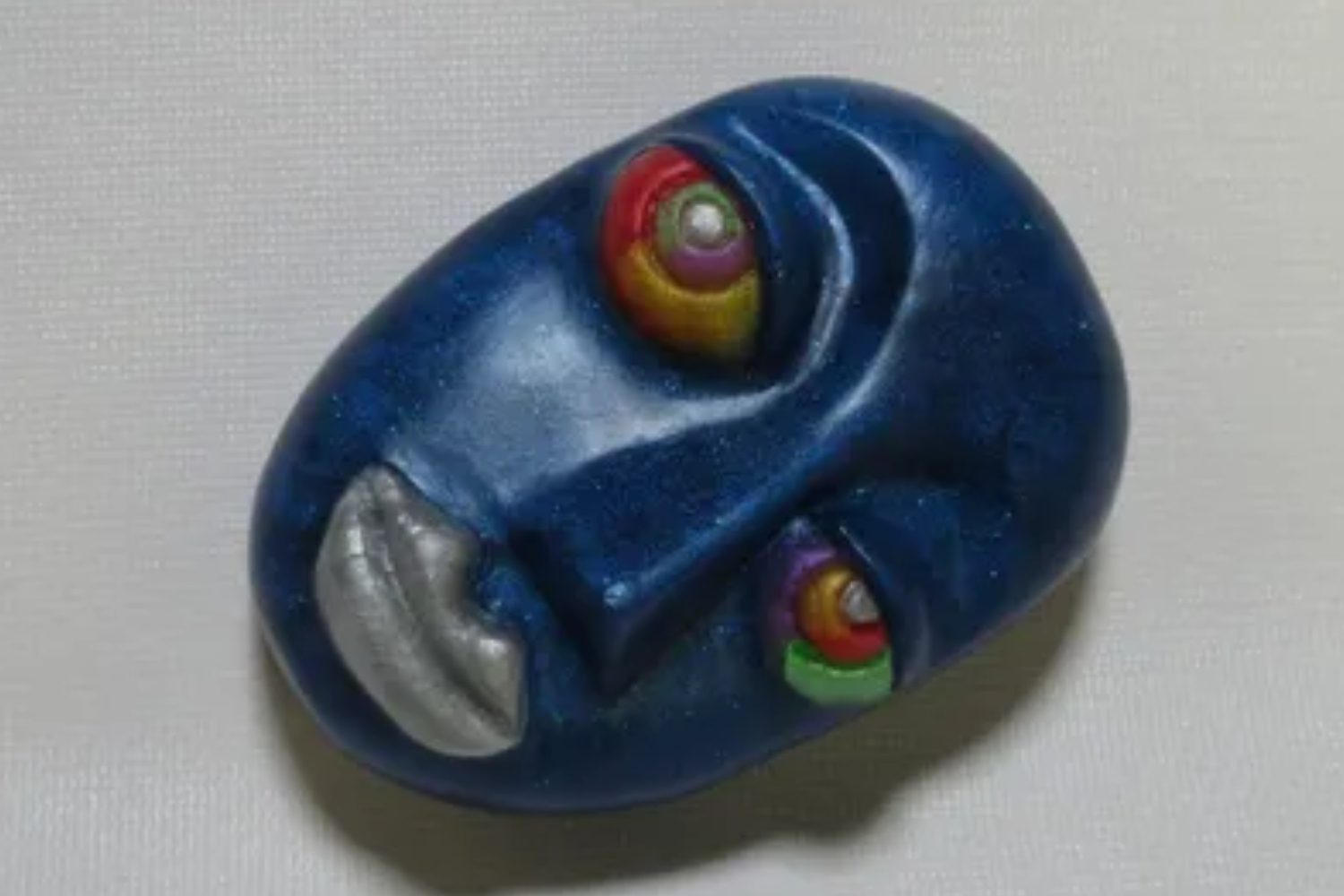 A blue face with colorful eyes and silver rim.