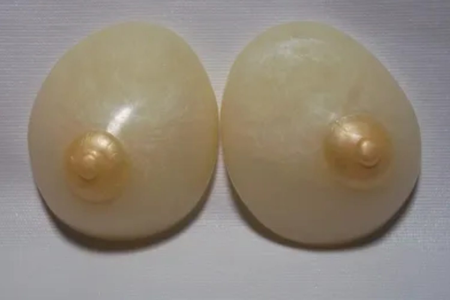 A pair of white buttons with pearls on them.